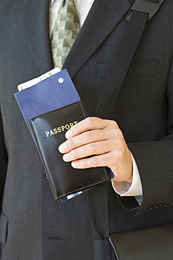 Businessman holding passport and airplane ticket