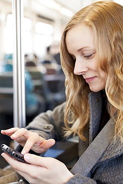 Woman sending text messages in subway train