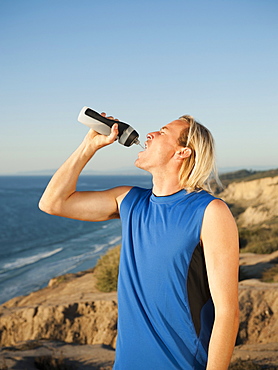 USA, California, San Diego, Male jogger drinking water from bottle