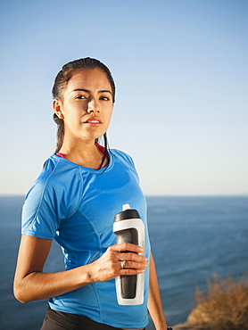 USA, California, San Diego, Portrait of female jogger holding water bottle