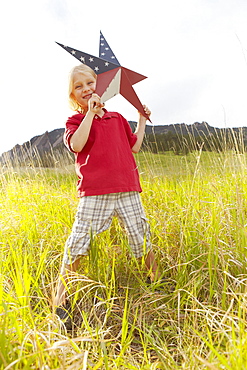 Boy (6-7) playing with star with American flag pattern