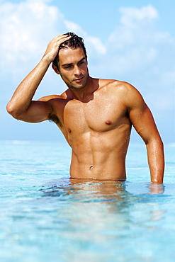 Smart young guy taking a bath in the ocean