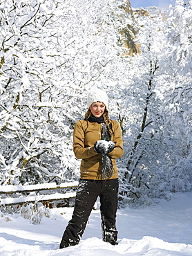 USA, Colorado, portrait of young woman making snowball