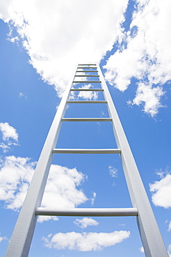 Ladder reaching cloudy sky