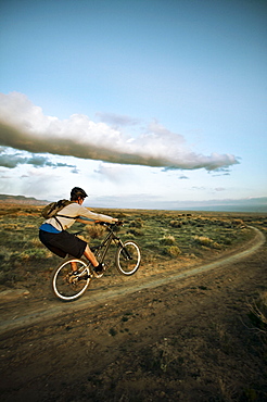 Man mountain biking on dirt track