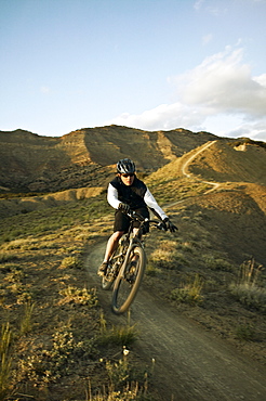 Man mountain biking on mountain track