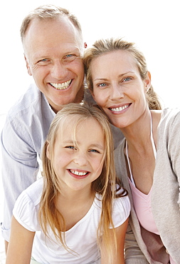 Girl (10-11) playing on beach with parents