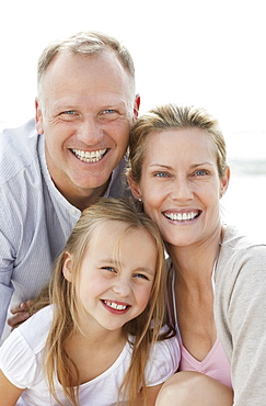 Girl (10-11) playing on beach with parents