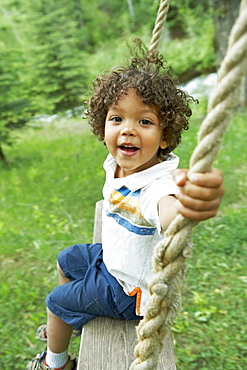 Cute young child sitting on swing