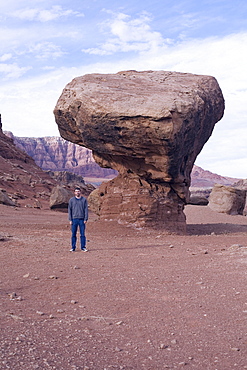 Tourist in front of butte in Arizona desert