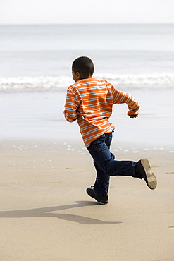 Young boy running on beach