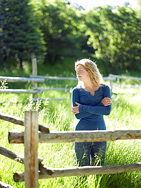 Young woman behind fence