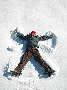 Woman making snow angel