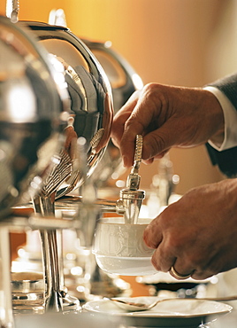 Man pouring tea from samovar