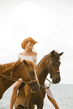 Woman riding horse on beach