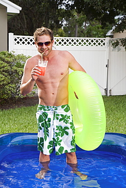 Man standing in inflatable swimming pool