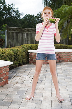 Girl eating watermelon on patio