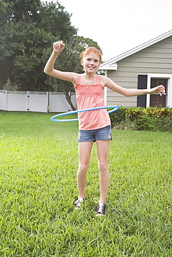 Girl hula hooping in backyard