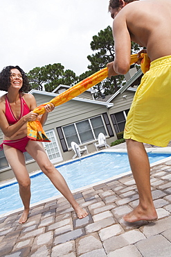 Couple playing tug-of-war with towel