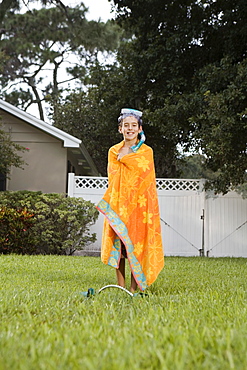 Boy wrapped in towel on lawn