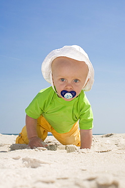 Baby boy crawling on beach