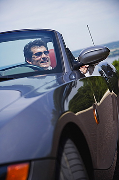 Man driving convertible car