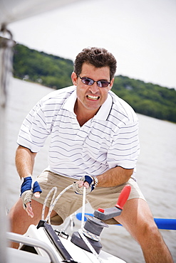 Man pulling rope on sailboat