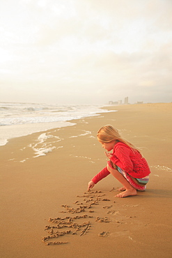 Girl drawing in sand