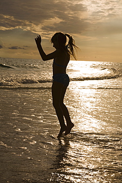 Girl in ocean surf at sunset, Florida, United States