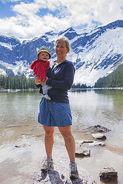 Woman with son (4-5) standing on lakeshore, Avalanche Lake, Glacier National Park, Montana, USA