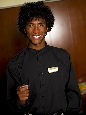 Young male receptionist giving card