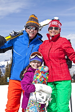 Grandparents with girl (10-11) posing during ski holiday