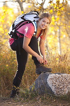 USA, Utah, young woman, woman tying laces in forest