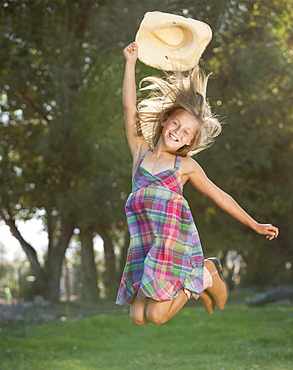 Portrait of smiling cowgirl (8-9) jumping