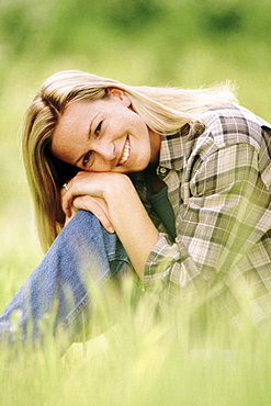 Pretty woman relaxing on grass in meadow