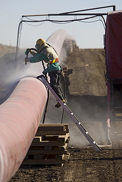 Construction worker cleaning pipeline