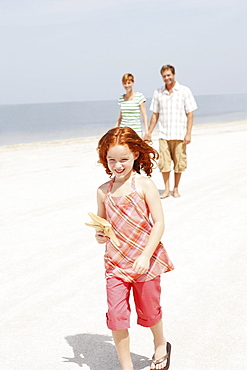 Couple and daughter walking on beach