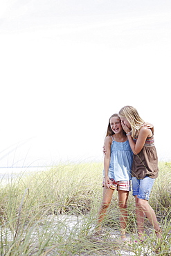 Girls whispering in beach grass