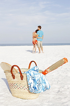 Young couple and beach essentials on beach