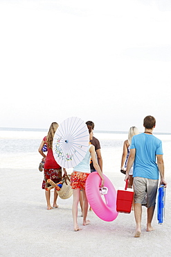 Friends walking with beach essentials