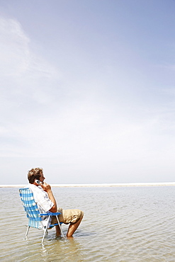 Man talking on cell phone in middle of water