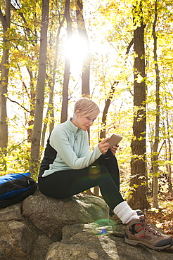 Female hiker using digital tablet in forest