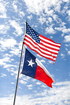 American and Texas flags against cloudy sky, Texas, USA