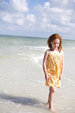 Girl walking through ocean surf