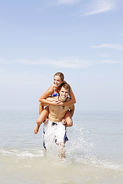 Couple splashing in ocean surf