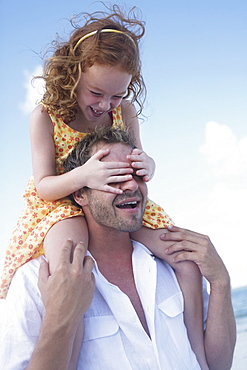 Father carrying daughter on shoulders