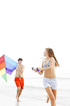 Friends flying kite on beach