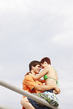 Young couple hugging on boardwalk railing