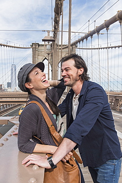 Happy couple flirting on Brooklyn Bridge, Brooklyn, New York