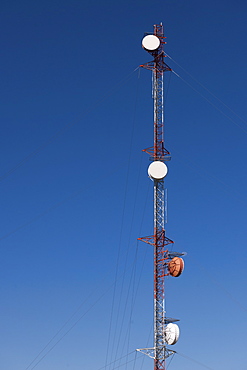 Tele-communications relay tower against blue sky